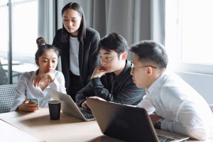 Business people in discussion over laptop computer screens