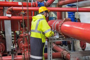 An engineer working on piping in a heating system