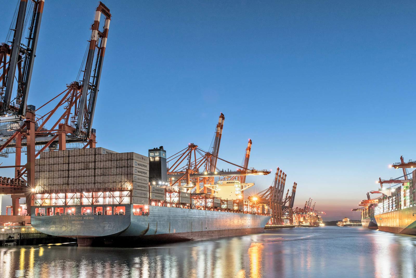 A container ship in port loading at night